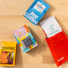  Four coffee bags from different roasters on a wooden surface. 